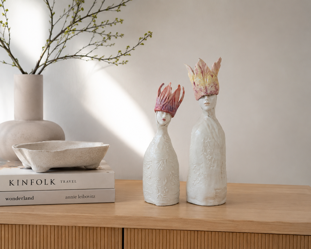 Handbuilt porcelain Tulip Queen sculptures displayed on a light wood sideboard