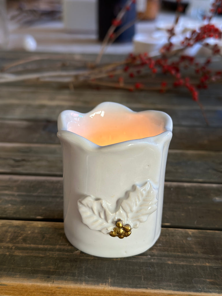 Decorative wall-mounted candle holder with floral design on a wooden surface